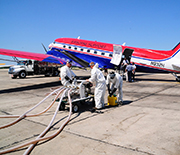 Workers loading chemical dispersants onto an airplane.